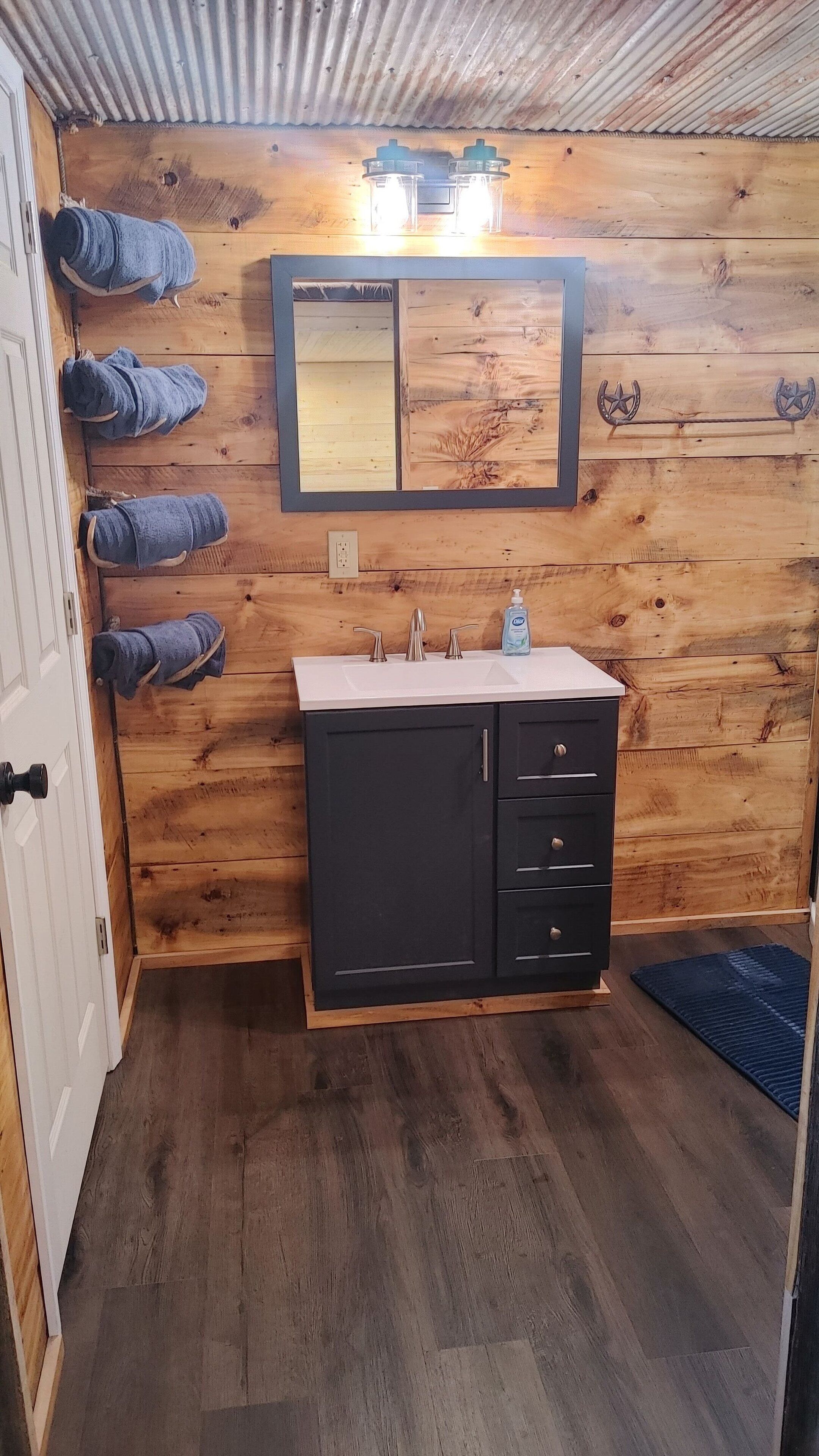 Een douche, handdoeken, zeep, toiletpapier