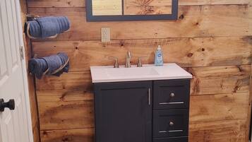 Chuveiro, toalhas de banho, sabonete, papel higiênico