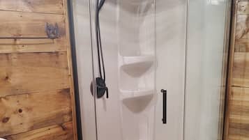 Een douche, handdoeken, zeep, toiletpapier