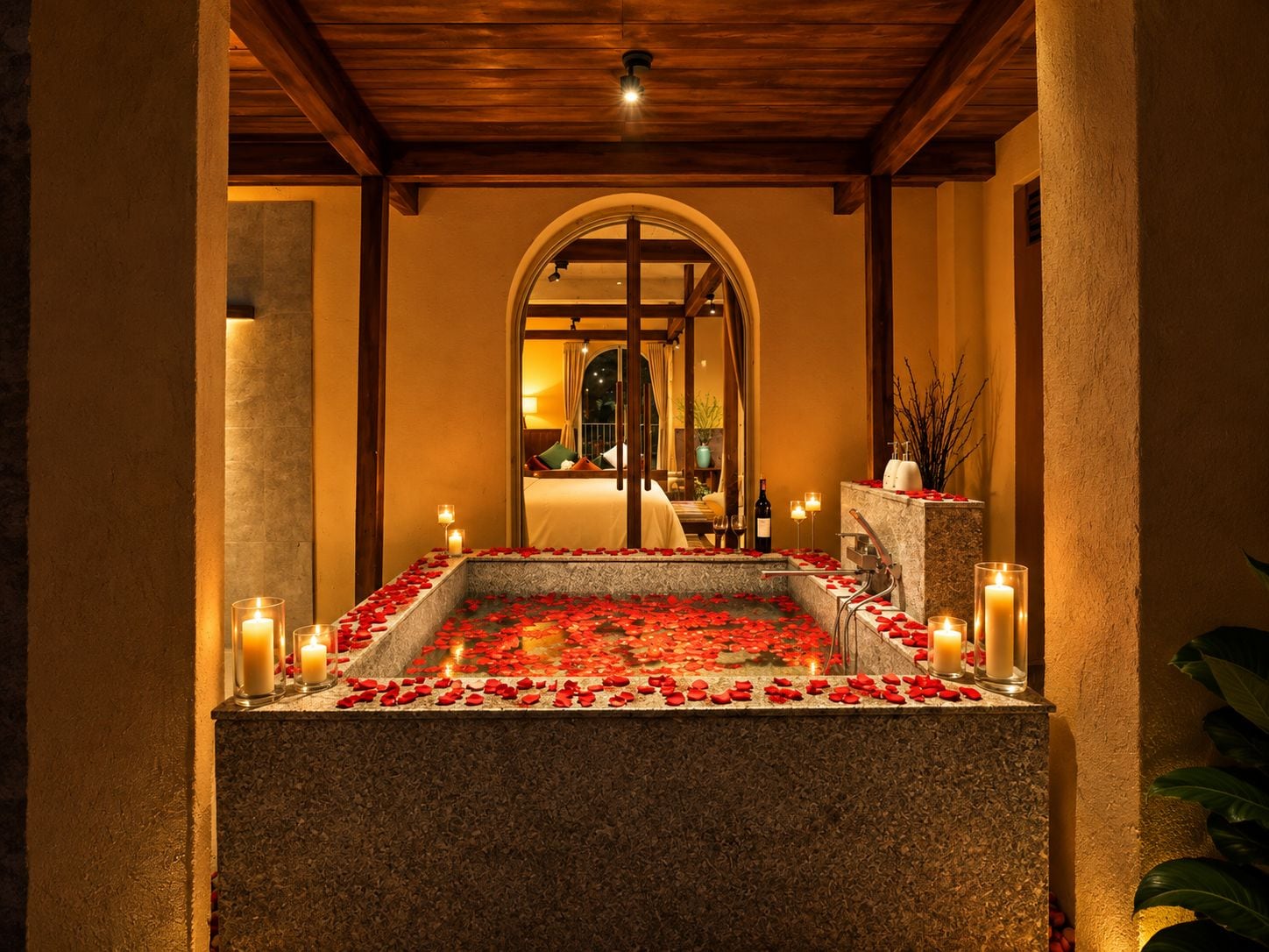 Una piscina con baldosas de piedra, pétalos de rosa y velas, rodeada de pilares y un techo de madera.