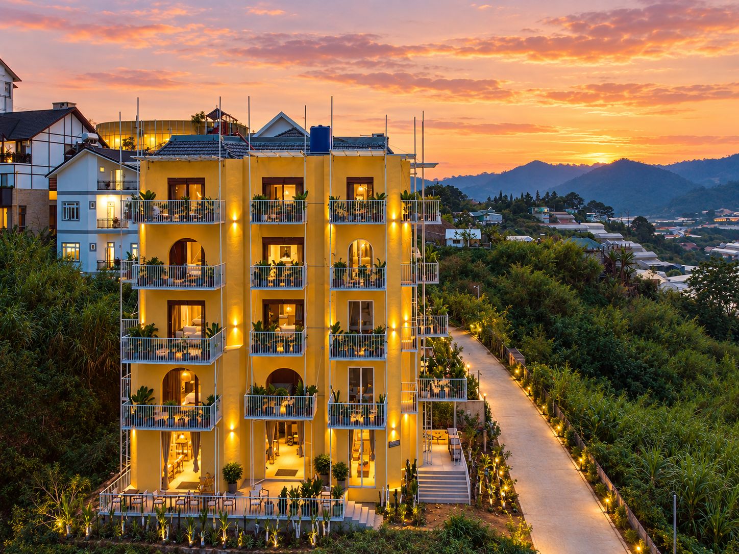 Ein mehrstöckiges Hotel mit Balkonen, einem Weg und Blick auf die umliegende Landschaft.