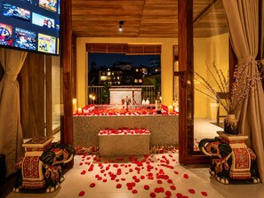 A romantic setup with rose petals, candles, and a bathtub in a hotel room. - Nexus House An Son Da Lat (Xuan Huong - Da Lat)