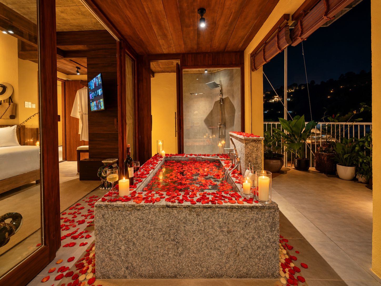 Una habitación con un banco de piedra, velas y pétalos de rosa.