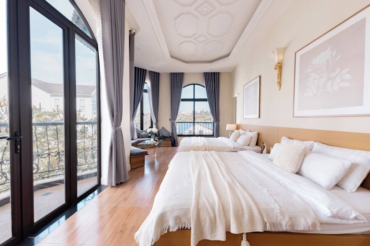 Een hotelkamer met een groot bed, een slaapbank en een balkon met uitzicht.