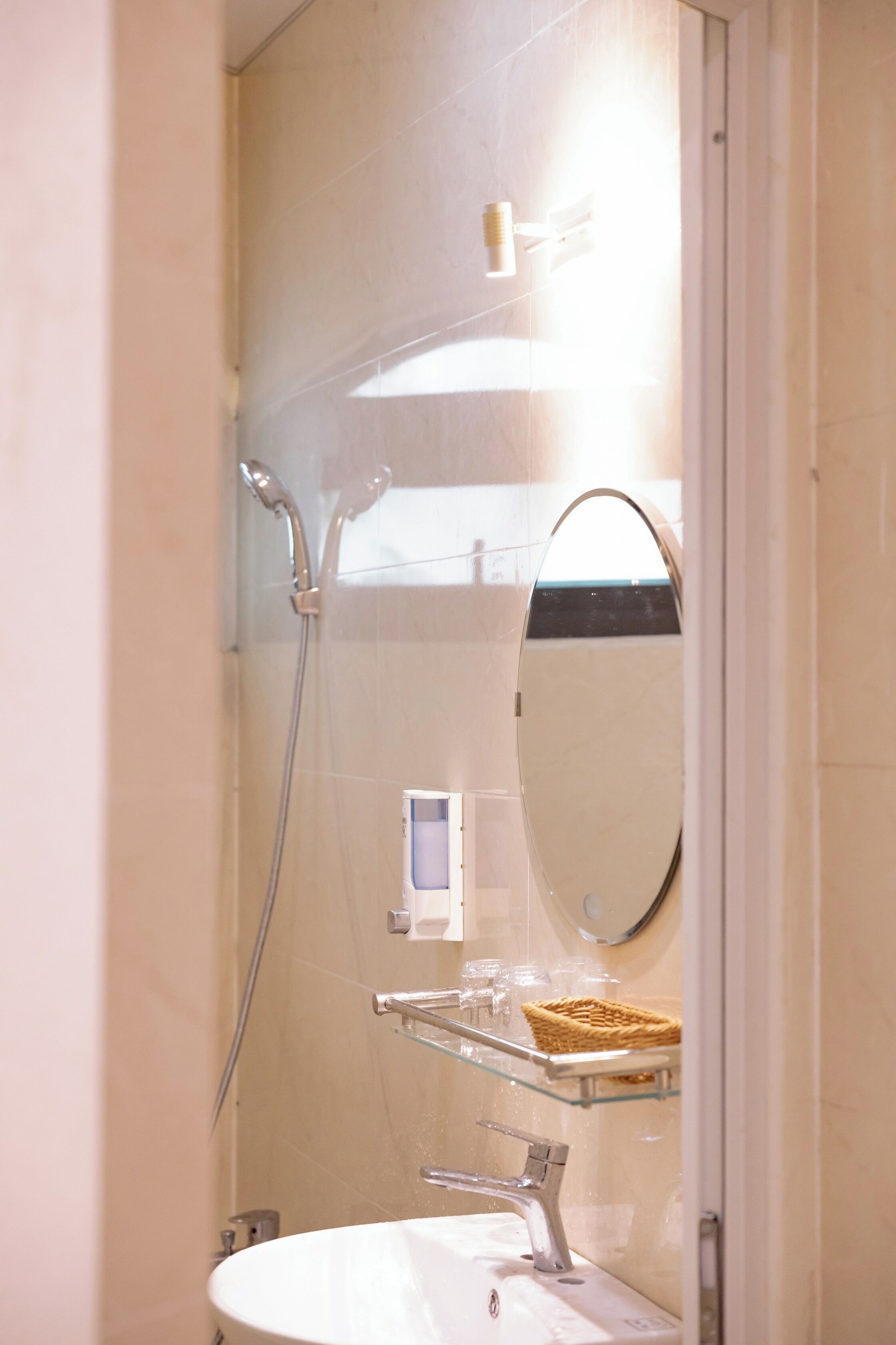 Ein Badezimmer mit einer Glasablage, einem Spiegel und einer Dusche.