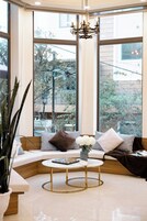 A cozy corner seating area with a round coffee table, a sofa with cushions, and a potted plant.