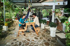 Un patio con suelo de piedra, muebles de madera y plantas en macetas.