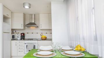 Een koelkast, een magnetron, kookgerei, borden en bestek