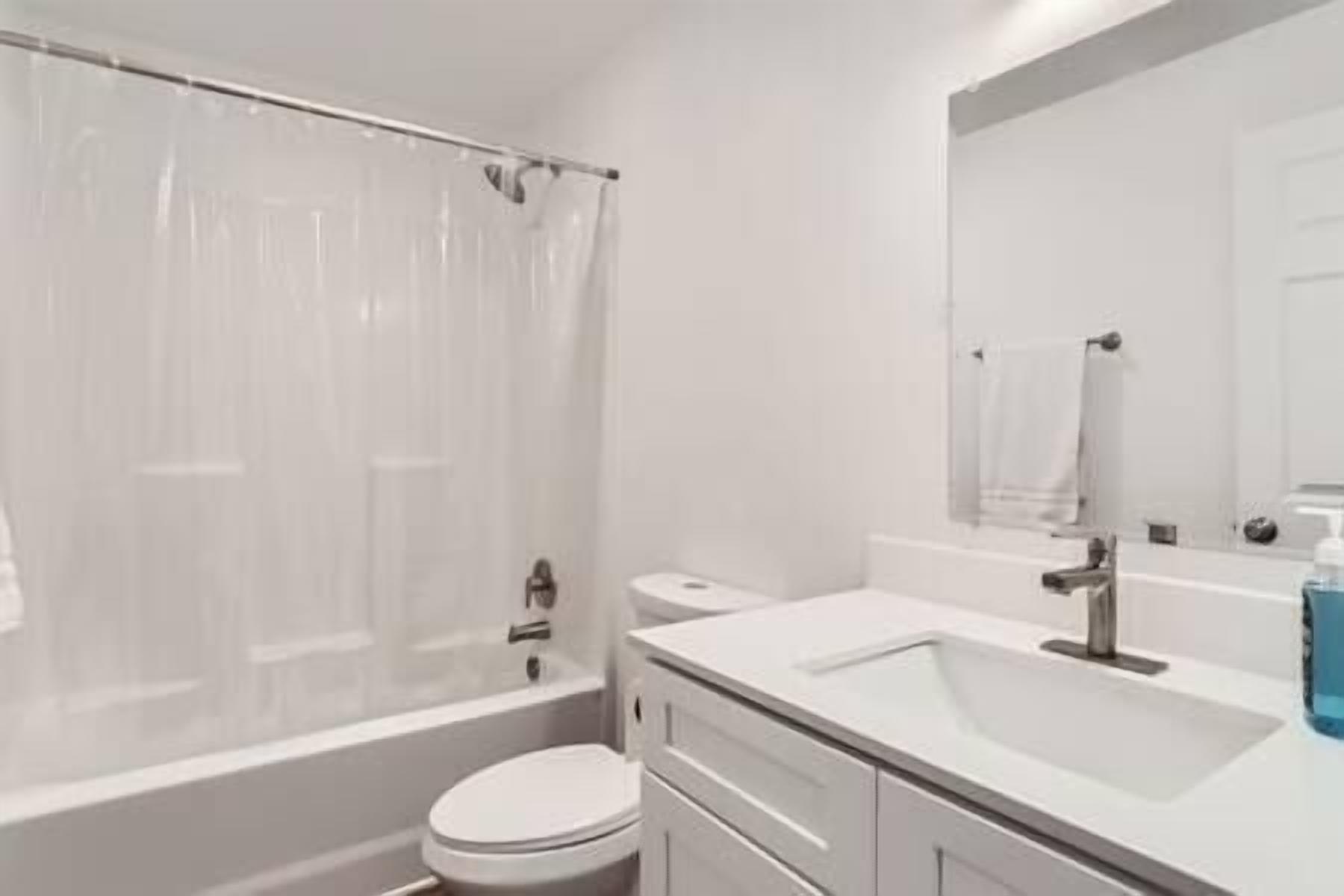 A bathroom with a bathtub, toilet, and sink.