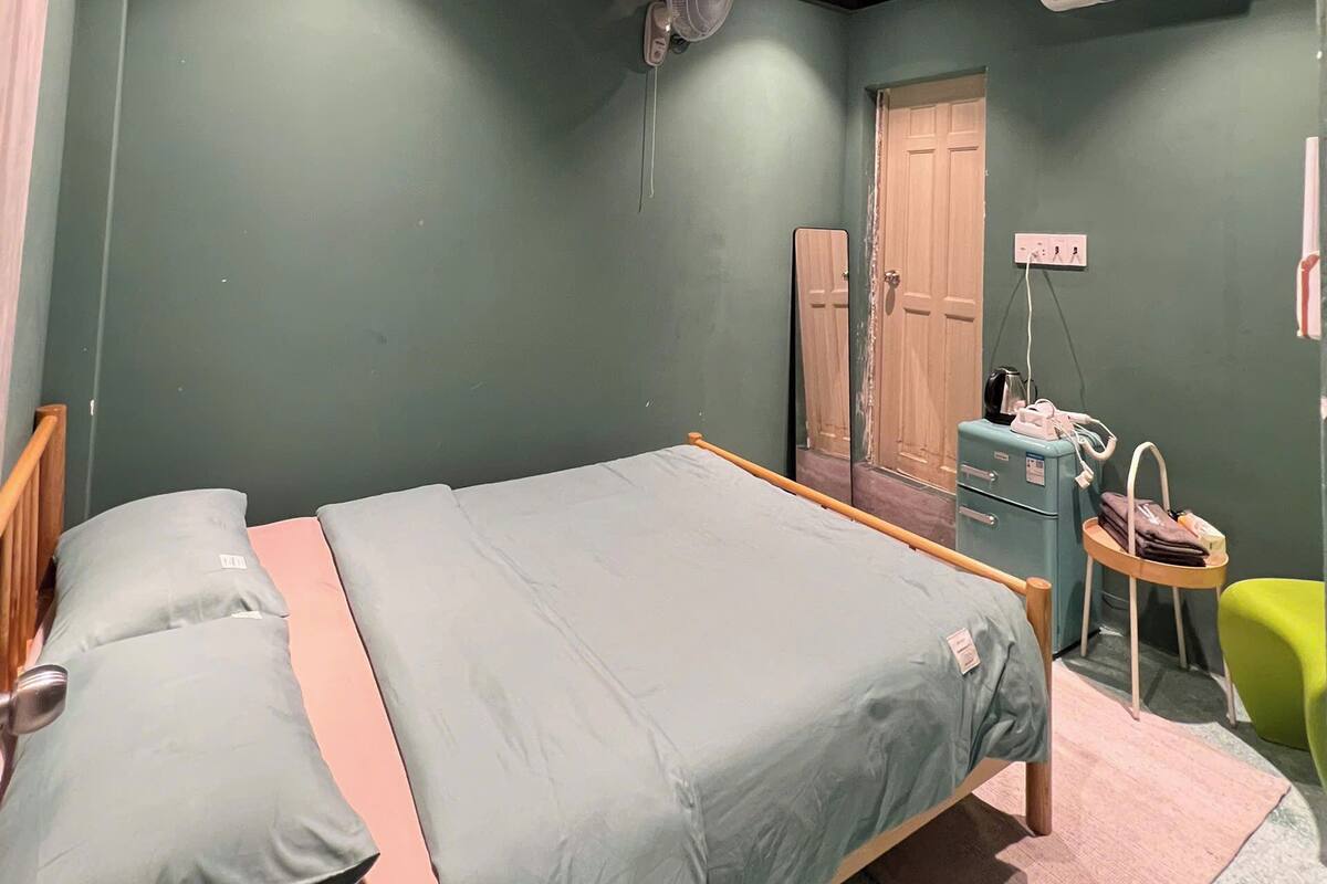 Une chambre à coucher avec un lit, un bureau, un climatiseur et un miroir.