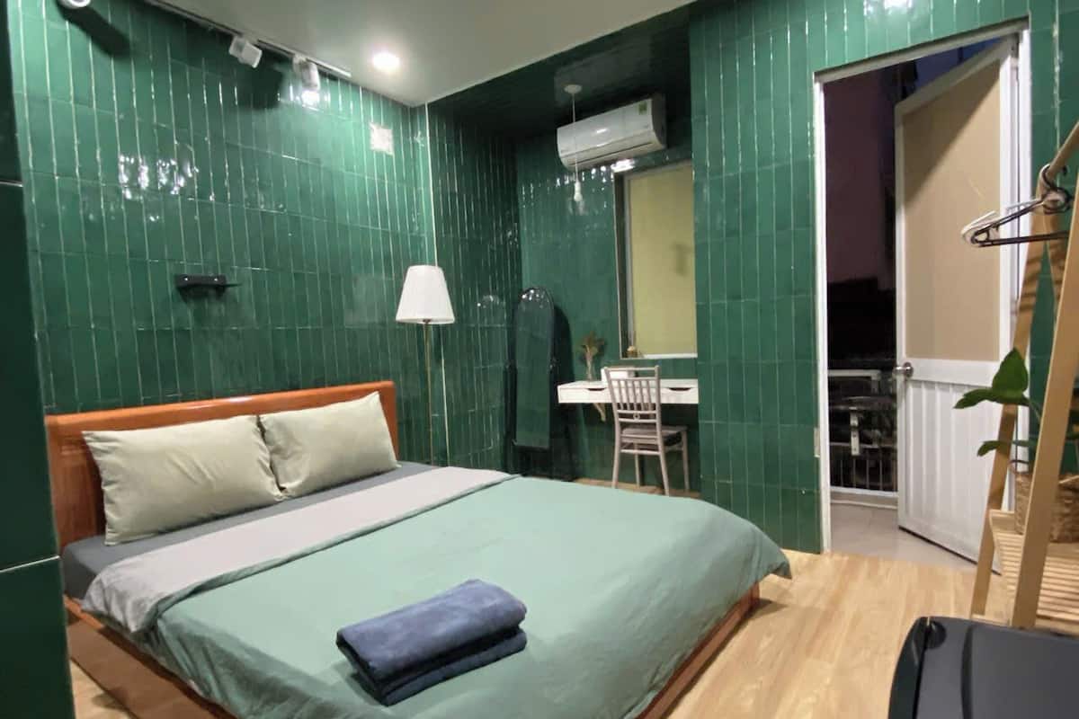 Une chambre d’hôtel avec un lit, un bureau et une chaise.