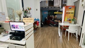 Un espace d’accueil comprenant un ordinateur, un comptoir de réception et un panneau indiquant « Accueil ».