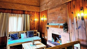 A cozy room with a wooden bench, a table, and a fireplace.