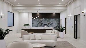 A modern living room with a sectional sofa, a round coffee table, and a decorative wall with a perforated pattern.