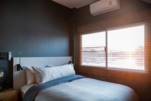 A hotel room with a large bed, a bedside table with a lamp, and a window with blinds. - Baanmax Boutique Pet Resort & Lodge, Chiangrai (Chiang Rai)