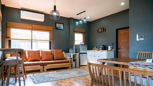 Een moderne keuken met houten kastjes, een eettafel en een bank met kussens.