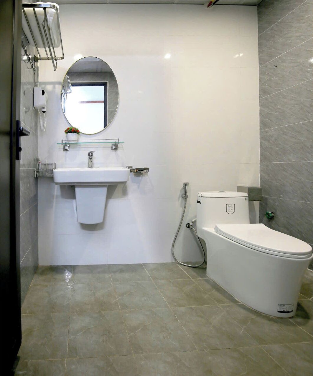A modern bathroom with a white sink, a toilet, and a mirror.