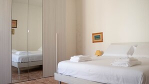 Une chambre d’hôtel avec un lit, une armoire, une table de chevet et un tableau encadré au mur.