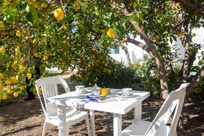 A table set outdoors with chairs, a book, and a teapot. - Melograno apartment (Loculi)