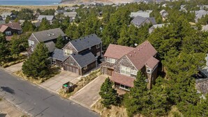 A residential area with houses, a road, and a hilly landscape in the background. - Beachcomber Cottage · Close to Beach, Family Friendly, Open Layout (Pacific City)