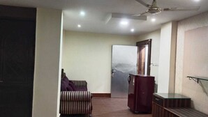 A room with a ceiling fan, a door with a frosted glass panel, a striped sofa, and a small table.