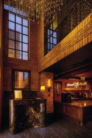 A restaurant interior with brick walls, large windows, and a neon sign. - Brooklyn Blues (Seoul)