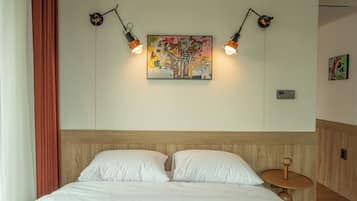 A neatly made bed with white linens, a wooden headboard, and a wall-mounted painting with two wall-mounted lights.