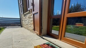 A stone-paved walkway leading to a building with a wooden door and a glass window.