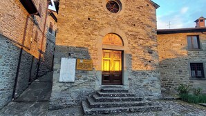 A stone building with a central arched doorway and a circular window above it.