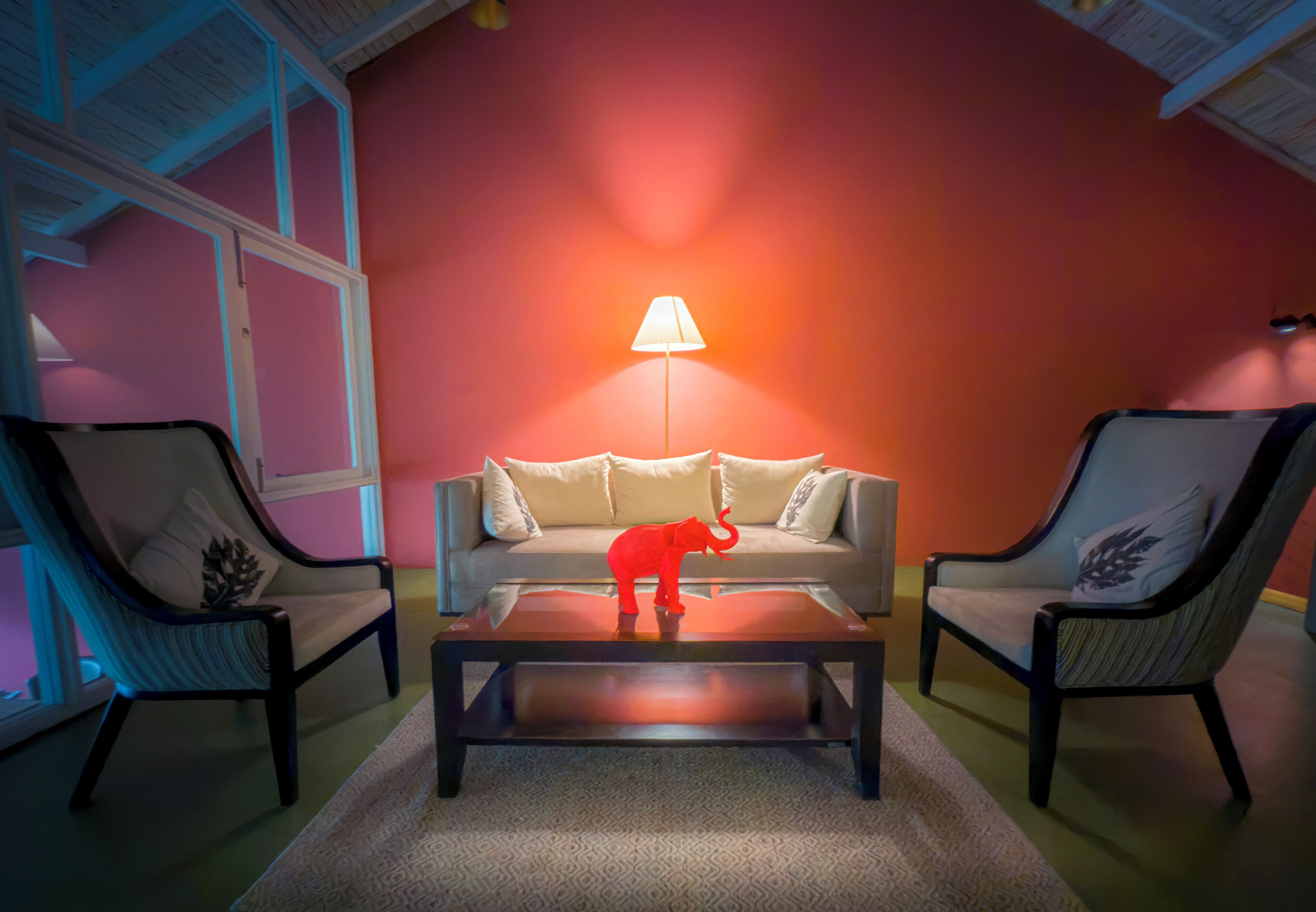 Una habitación con sofá, dos sillones, una mesita de centro y una lámpara.