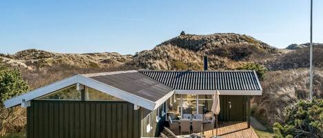 Une maison moderne dotée d’une grande terrasse et d’un espace extérieur couvert.