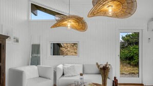 A modern living room with white walls, two sofas, a wooden coffee table, and a large window with a view of greenery. - "Gundborg" - 200m from the sea by Interhome (Saltum)