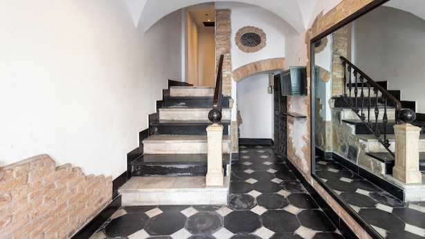 A staircase with black and white patterned flooring, stone walls, and a wooden railing. - Beautiful House In Porta Soprana Genova (Genoa)