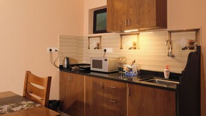 Une cuisine de taille réduite, dotée de meubles en bois, d’un four à micro-ondes et d’un évier.
