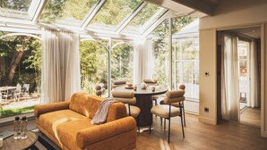 A modern living room with a sofa, round dining table, and chairs. - Parc Victoria Appartements (Saint-Jean-de-Luz)