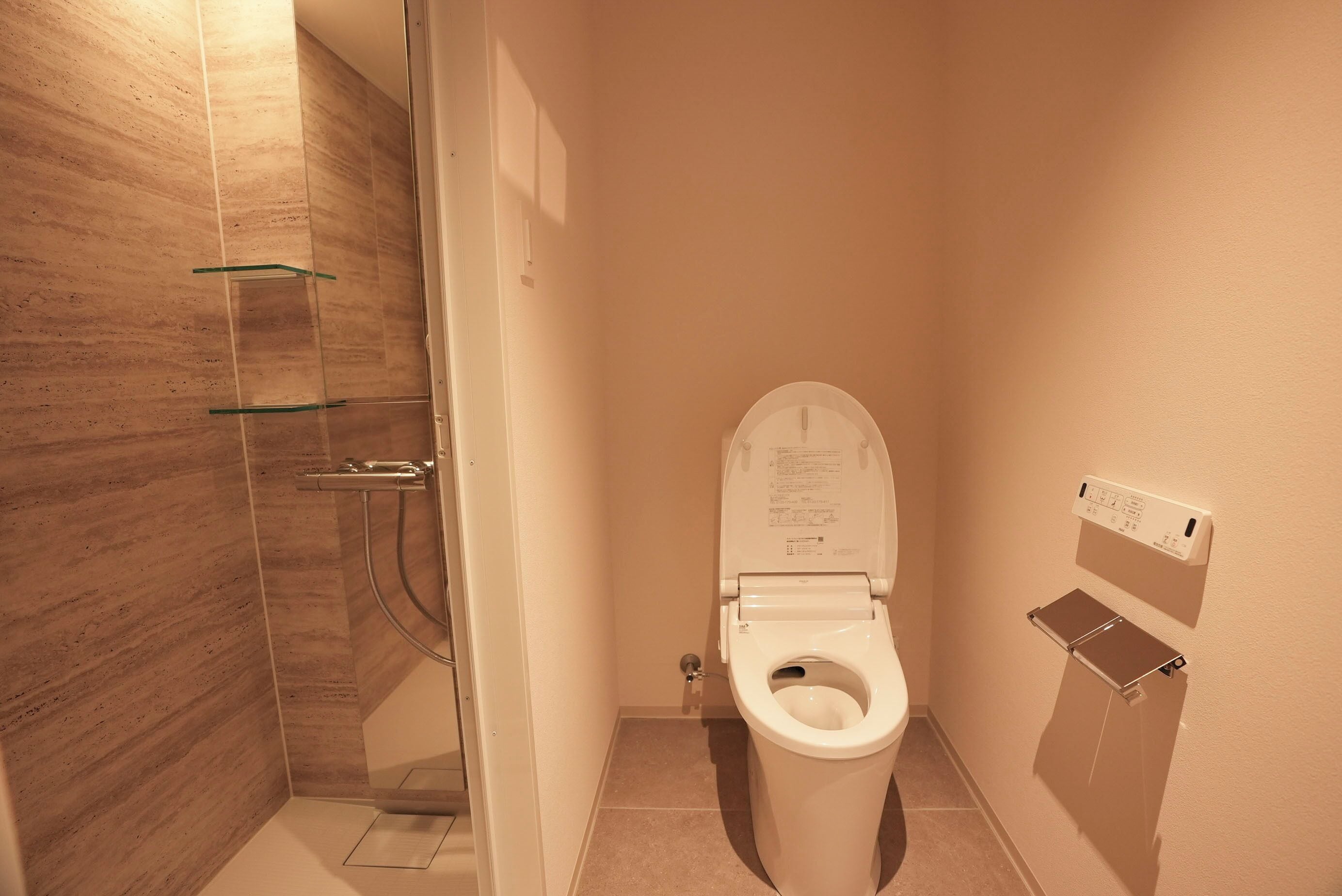 Un baño con ducha, inodoro y un perchero para toallas.