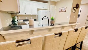 A modern kitchen with white cabinets, a black faucet, and a long countertop. - Eastgate 13A Cozy family retreat close to downtown Hammond (Hammond)
