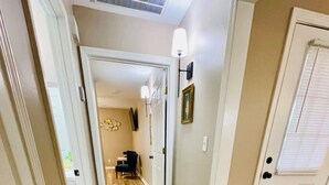 A hallway with wooden flooring, white doors, and a light fixture on the wall. - Eastgate 13A Cozy family retreat close to downtown Hammond (Hammond)