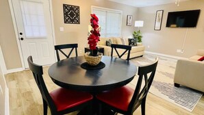 A dining area with a round table, red chairs, a chandelier, and a ceiling fan. - Eastgate 13A Cozy family retreat close to downtown Hammond (Hammond)