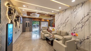 Eine moderne Lobby mit Marmorwand, einer Rezeption und gemütlichen Sitzbereichen.