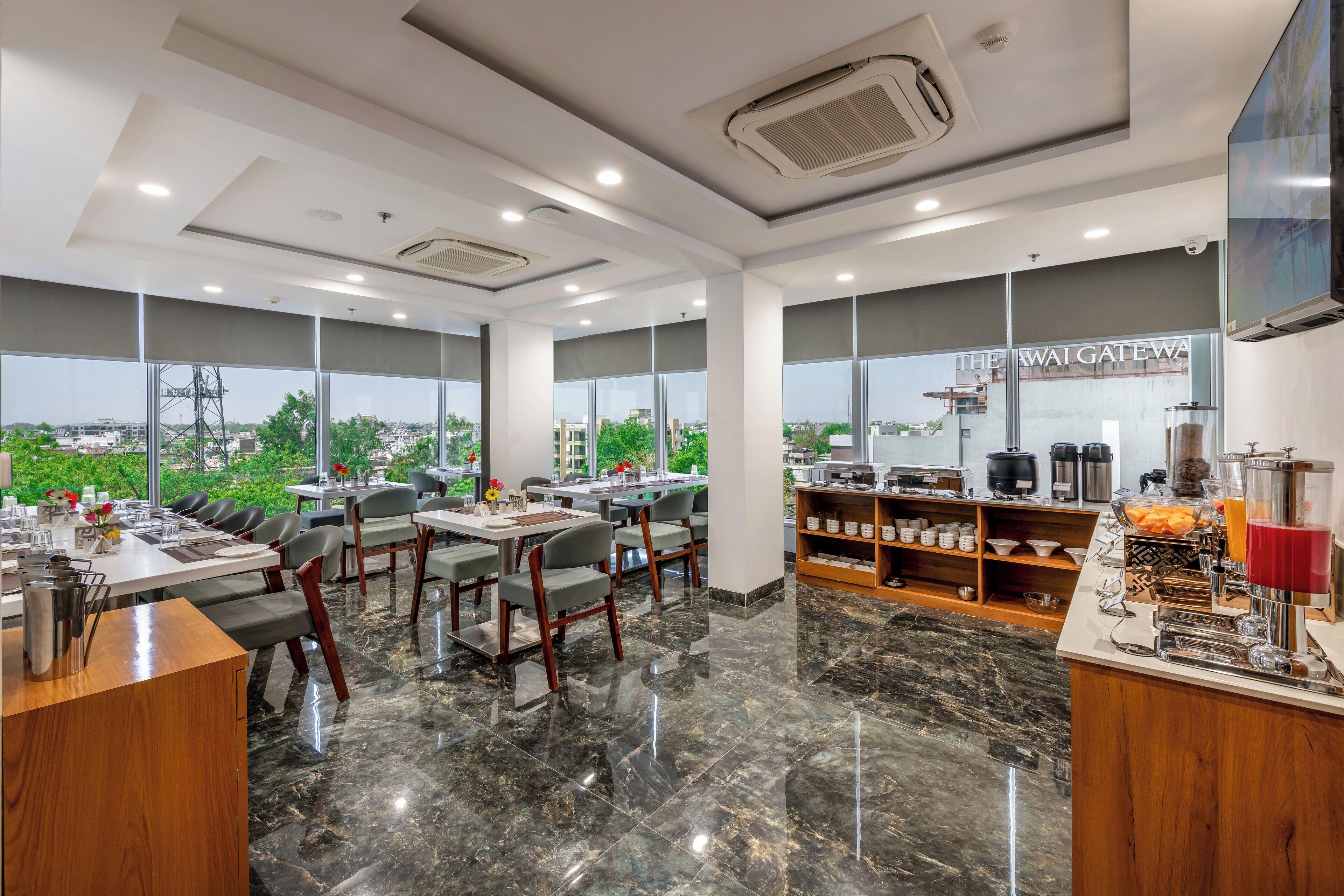 A modern restaurant with large windows, a buffet area, and a coffee station.