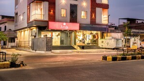 Ein mehrstöckiges Hotel mit modernem Design, mit Balkonen, großen Fenstern und einer gut sichtbaren Hotelschilderung.