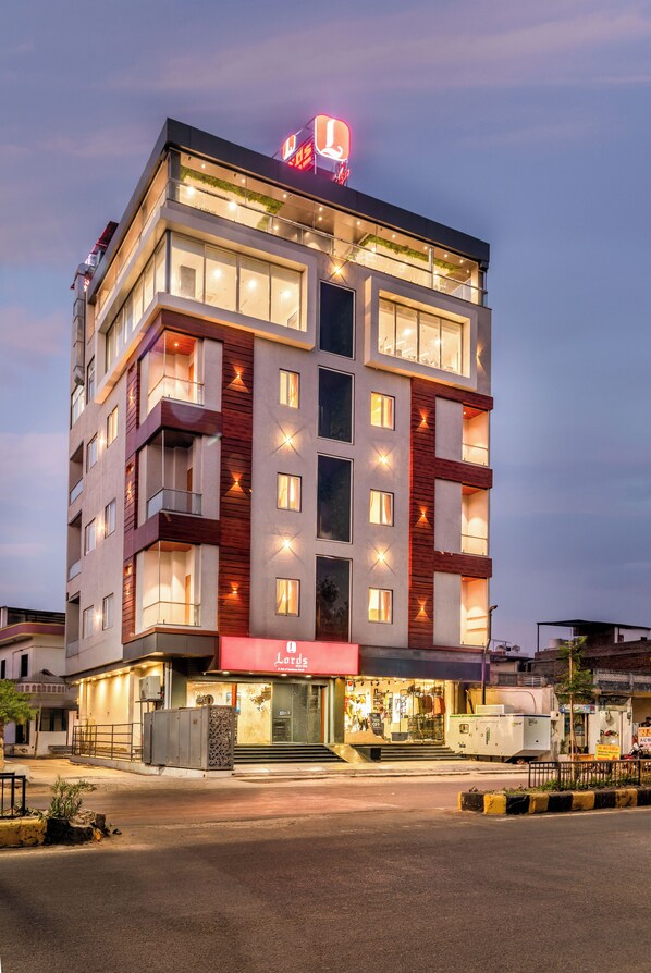 A multi-story hotel with a modern design, featuring balconies, large windows, and a prominent signage for the hotel.