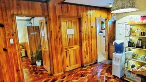 A wooden interior with a patterned floor, a water dispenser, and shelves with various items. - Room-premium Deluxe Room 2c-2ndf (Baguio)