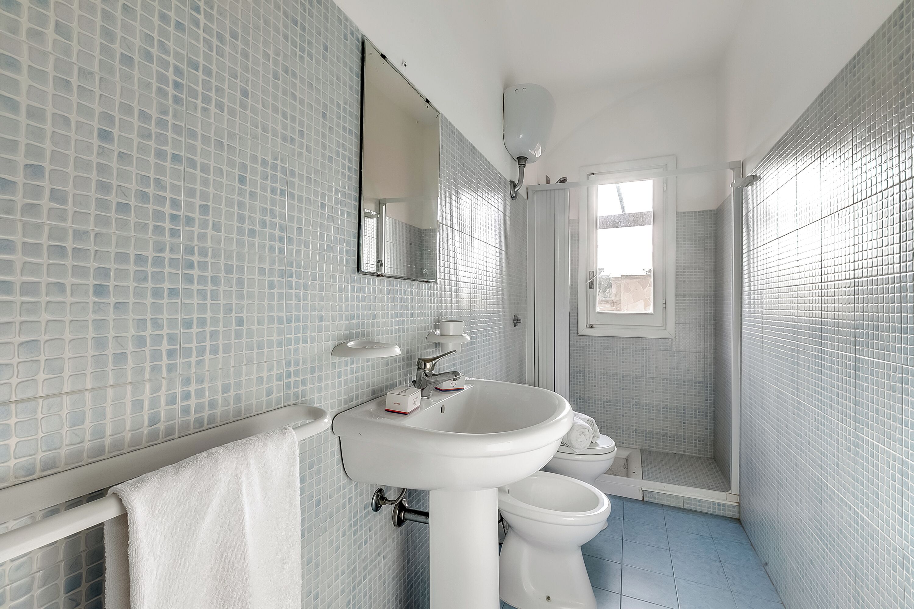 A bathroom with a white sink, a mirror, and a toilet.