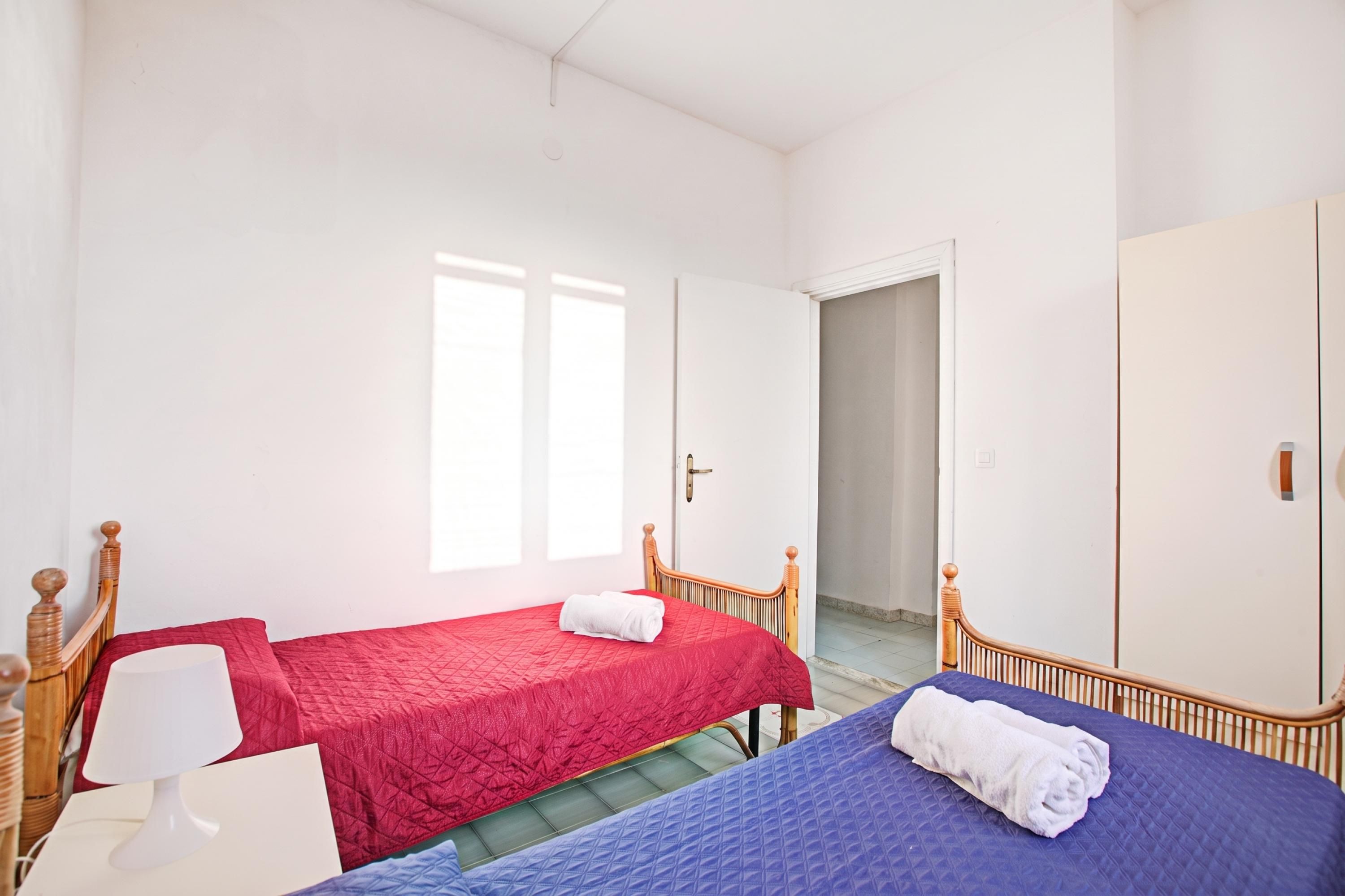 A room with two beds, a desk, and a wardrobe.