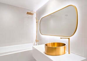 A bathroom with a white bathtub, a gold-framed mirror, and a gold basin. - Hotel Insta Main Branch (Suwon)