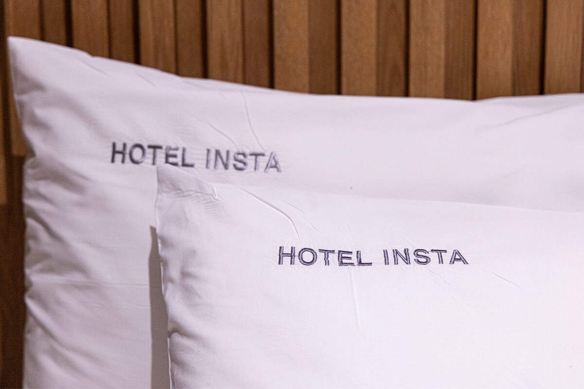 Dos almohadones con el texto 'HOTEL INSTA'.