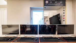 A hotel room with a desk featuring multiple monitors, a keyboard, and a mouse. - Insta Hotel - Main Branch (Suwon)