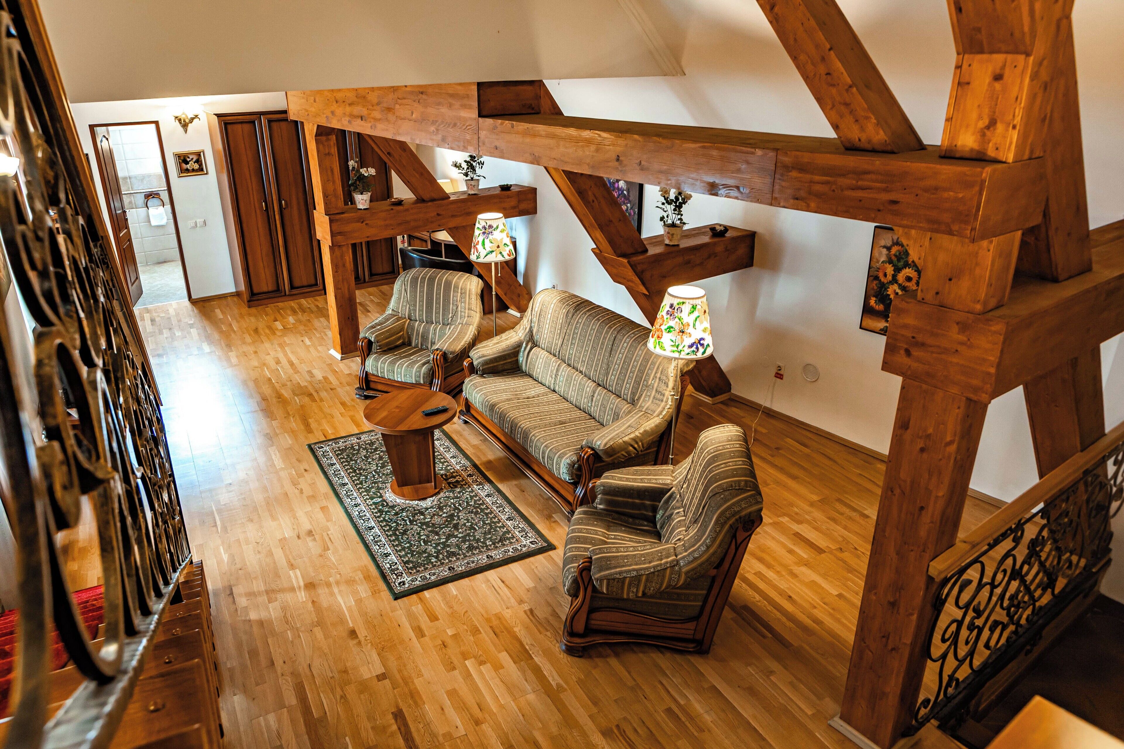 Un loft amplio con vigas de madera, un conjunto de sofás y una pequeña mesa.